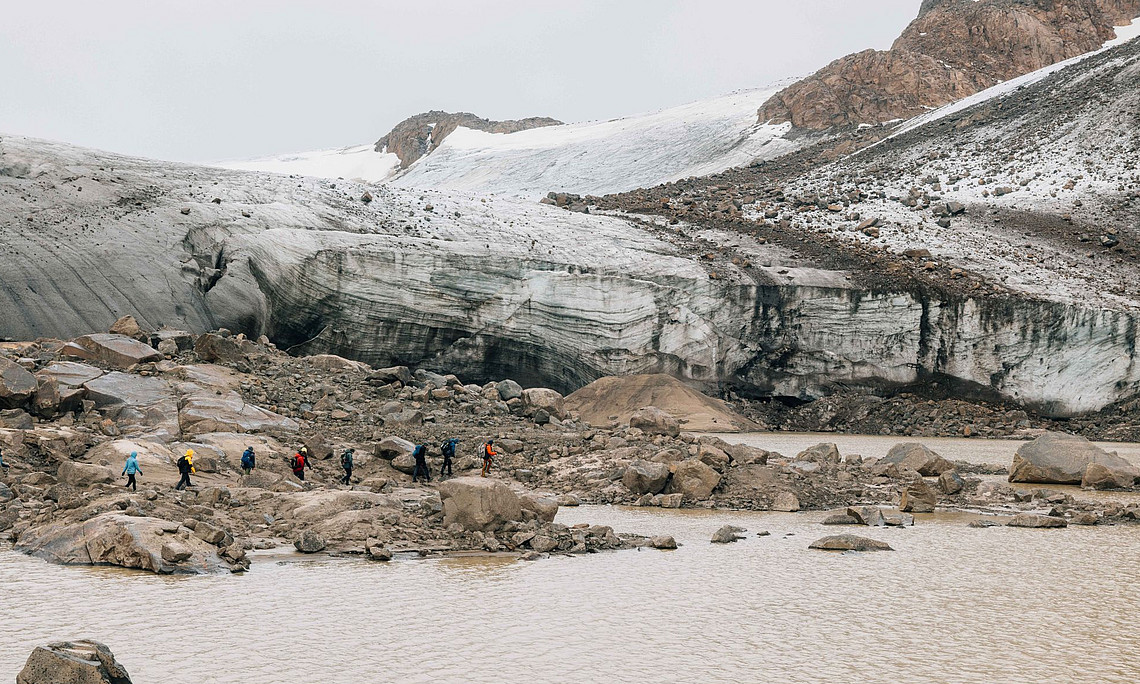 Eine Gruppe von Wissenschaftlern erforscht den Gletscher und den See aus der Perspektive einer ruhigen Atmosphäre. Die Szene fängt ihren Abenteuergeist ein, während sie eine e