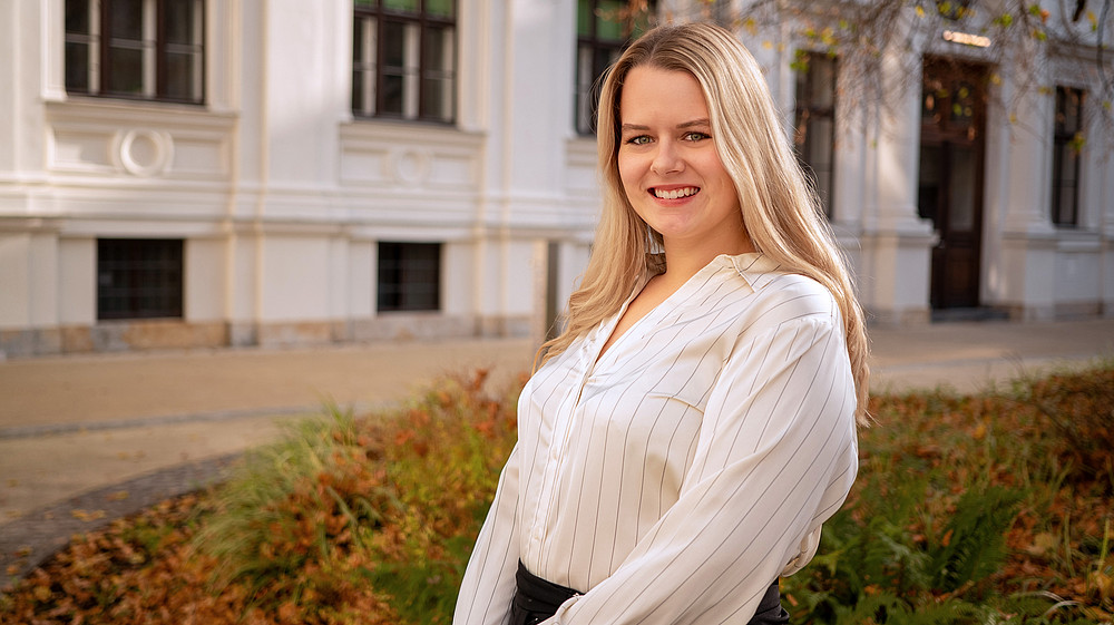 Frau Strasser in weißer Bluse im Innenhof der Universität Graz 