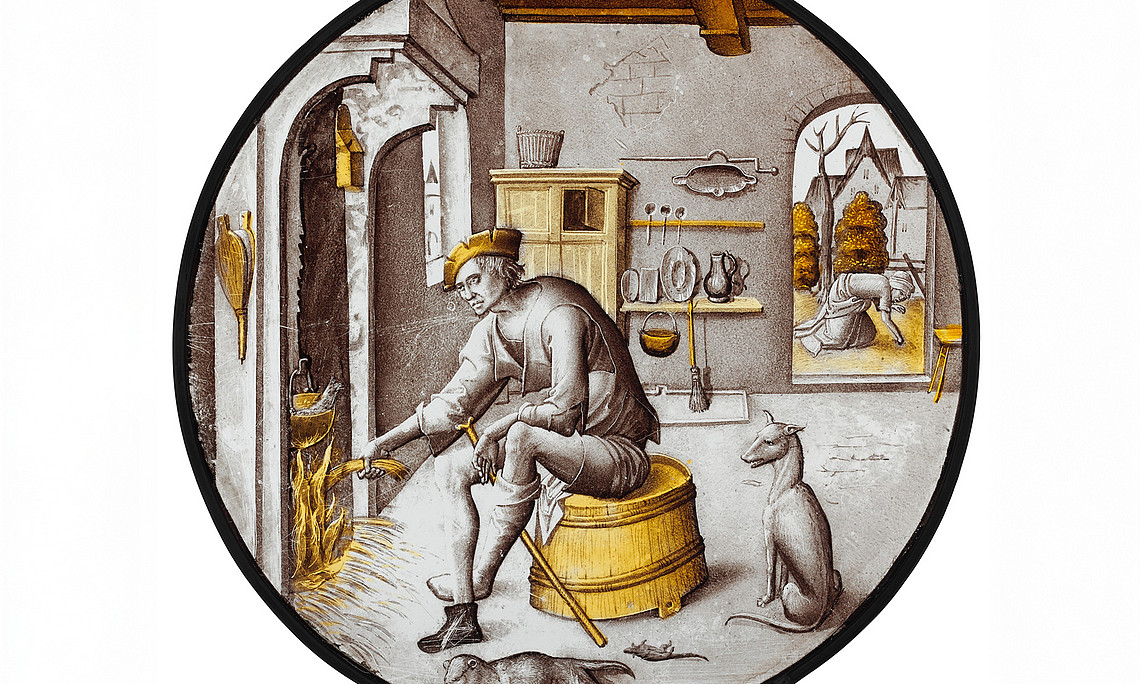 Medieval depiction of a poor man sitting in tattered clothes on an upturned tub, putting straw into a fire in the fireplace. A cooking pot with a fish hangs over the fire.
