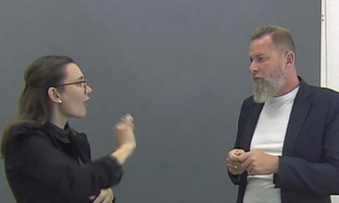 eine Frau und ein Mann (Christian Stalzer) gebärden miteinander