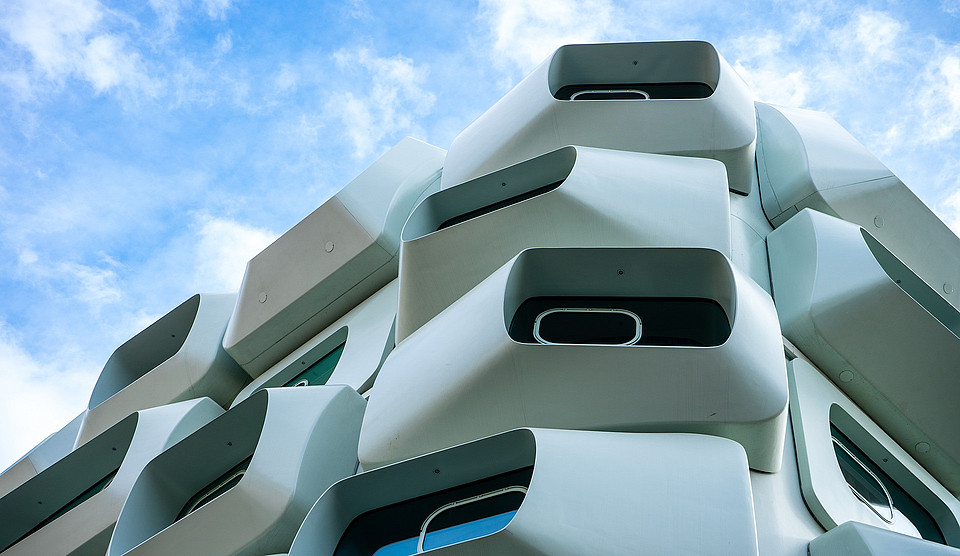 Nahaufnahme eines modernen Gebäudes in Graz, das ungewöhnliche Fenster hat