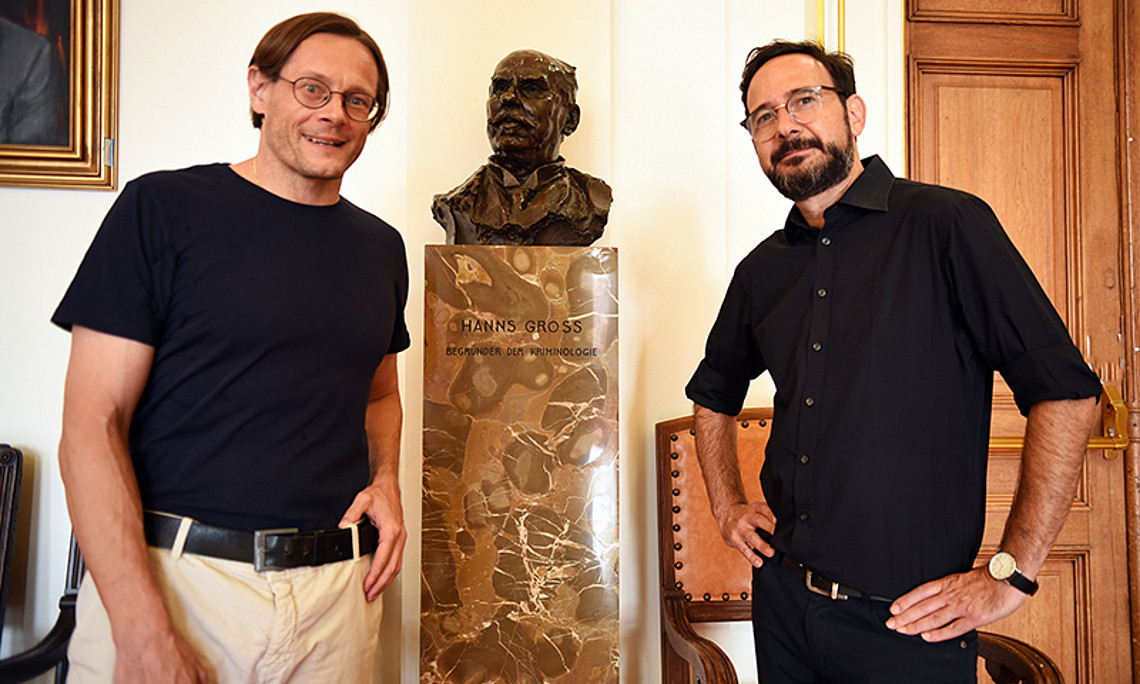 Christian Bachhiesl (links) und Gal Hertz vor der Hans-Gross-Büste in der Aula. Foto: Uni Graz/Schweiger