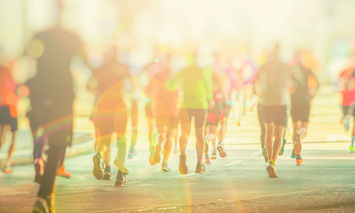 People in sportswear running on a street, blurred, from behind