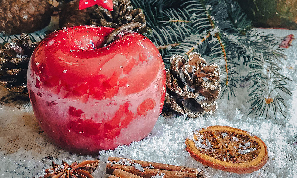 Weihnachtsdeko: roter Apfel, Sternanis, Zimtstangen, Föhrenzapfen, getrocknete Orangenscheibe, Tannenzweig, Schnee. Foto: pixabay