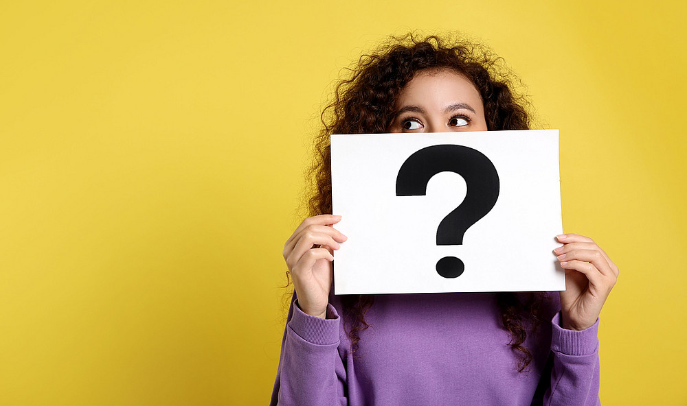 Eine Frau hält ein weißes Schild mit einem schwarzen Fragezeichen ©Olga Yastremska - stock.adobe.com