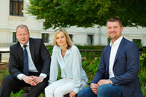 Christoph Bezemek, Marianne Pasterk und Sebastian Gölly sitzen Innenhof des Hauptgebäude der Universität Graz