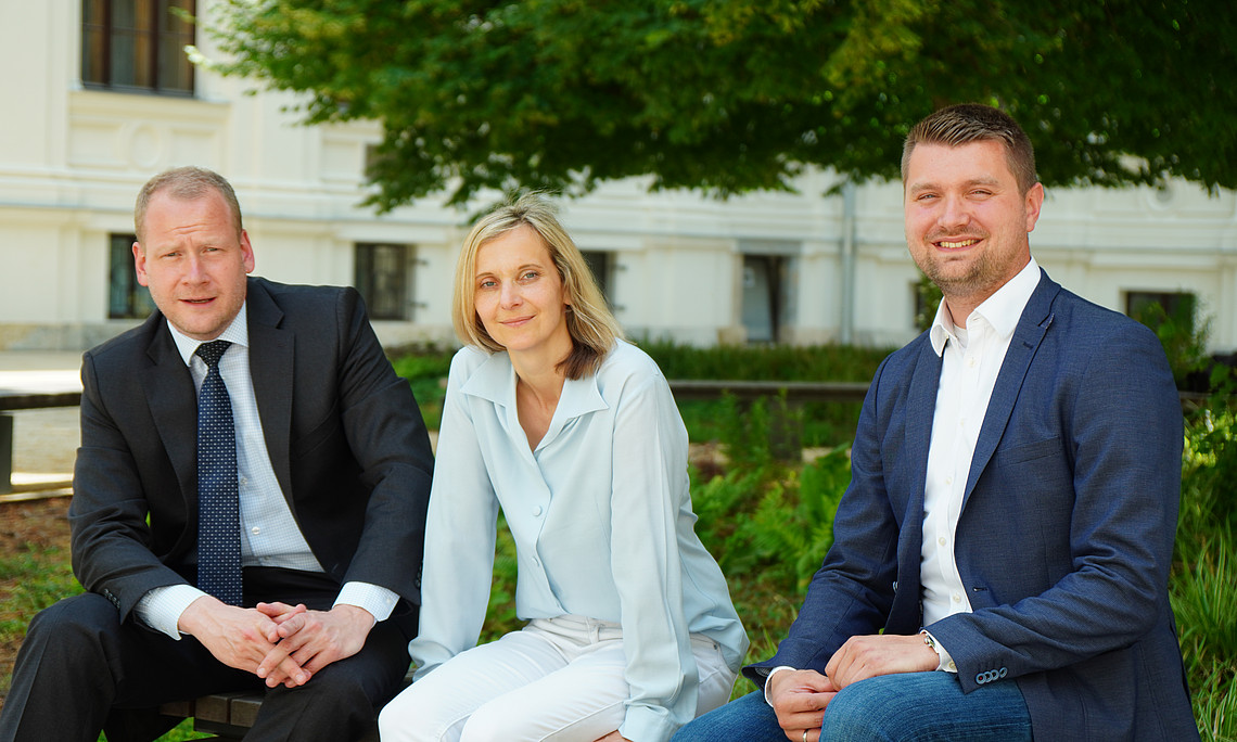 Christoph Bezemek, Marianne Pasterk und Sebastian Gölly sitzen Innenhof des Hauptgebäude der Universität Graz
