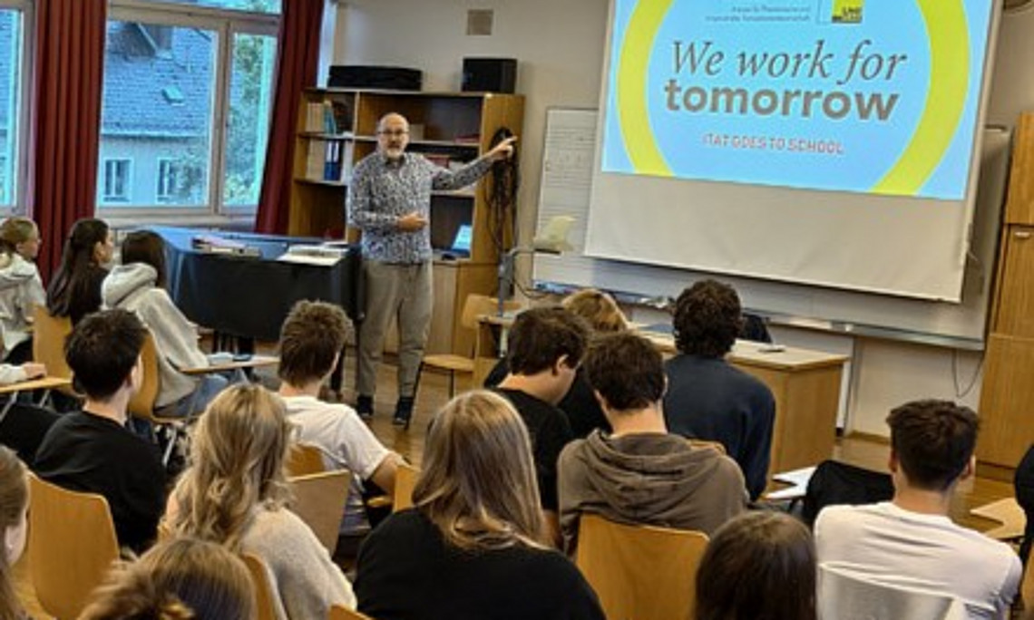 Professor präsentiert vor Schülergruppe