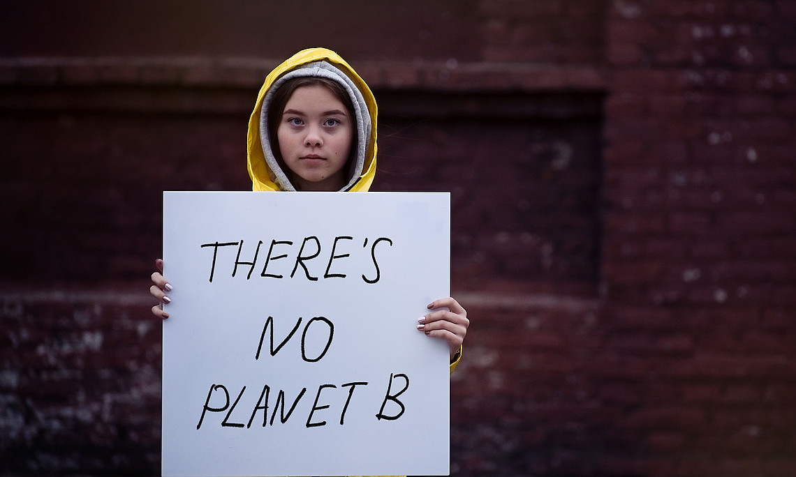 Teenager girl holding placard during global strike