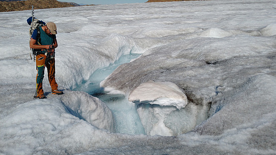 Ein supraglazialer Schmelzwasserabfluss am Mittivakkat Gletscher, der in einer Gletschermühle (moulin) mündet und in das englaziale und/oder subglaziale Abflusssystem abfließt