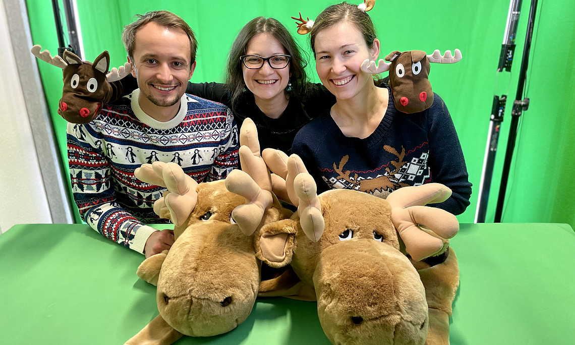 Drei Mitarbeiter*innen des Zentrums in Weihnachtskleidung.
