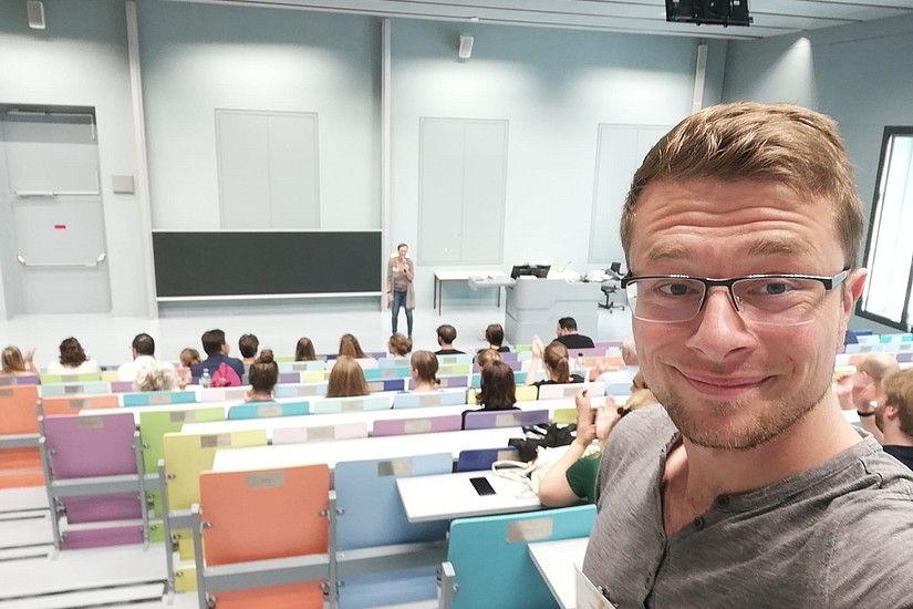 ein Selfie von Hilmar Brohmer, im Hintergrund der Hörsaal der Uni Graz