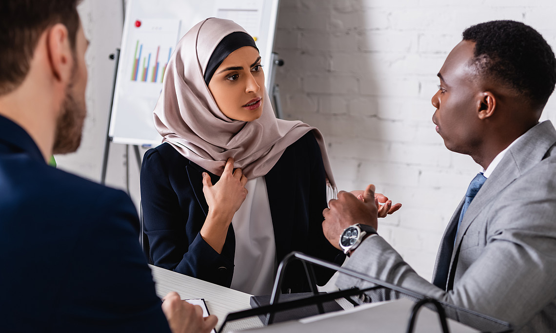 Frau mit Hijab redet mit Dolmetscherf