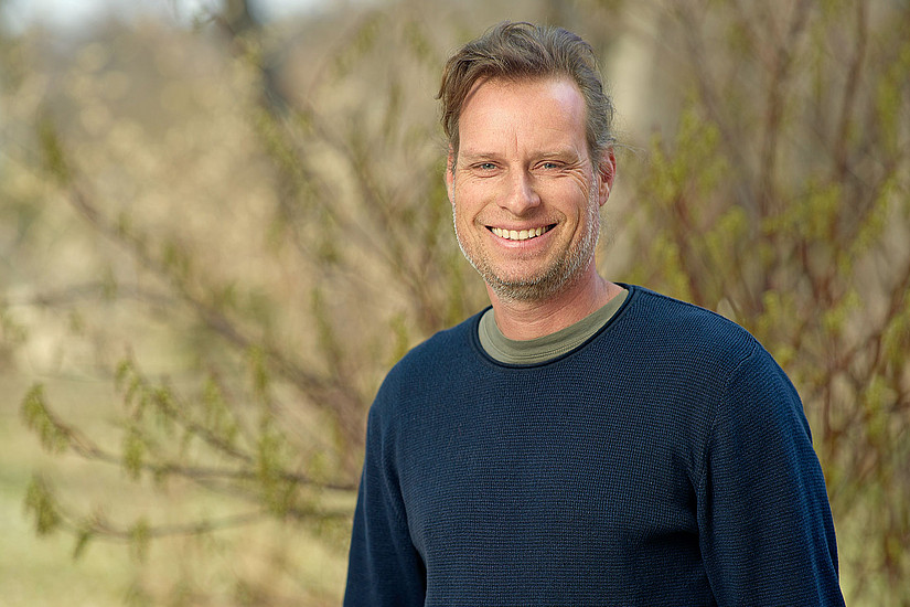 Biologe Gernot Kunz vor einem Strauch im Botanischen Garten der Universität Graz