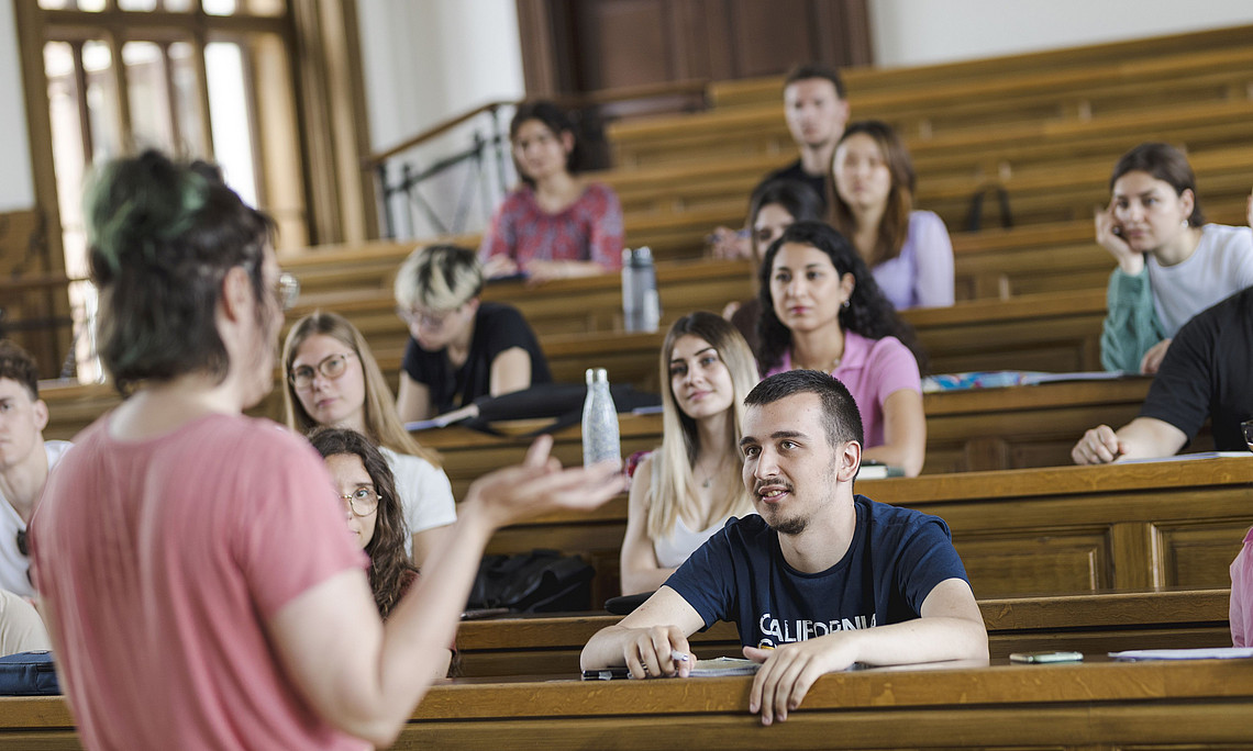 Vortragende in einem Hörsaal voller Studierende