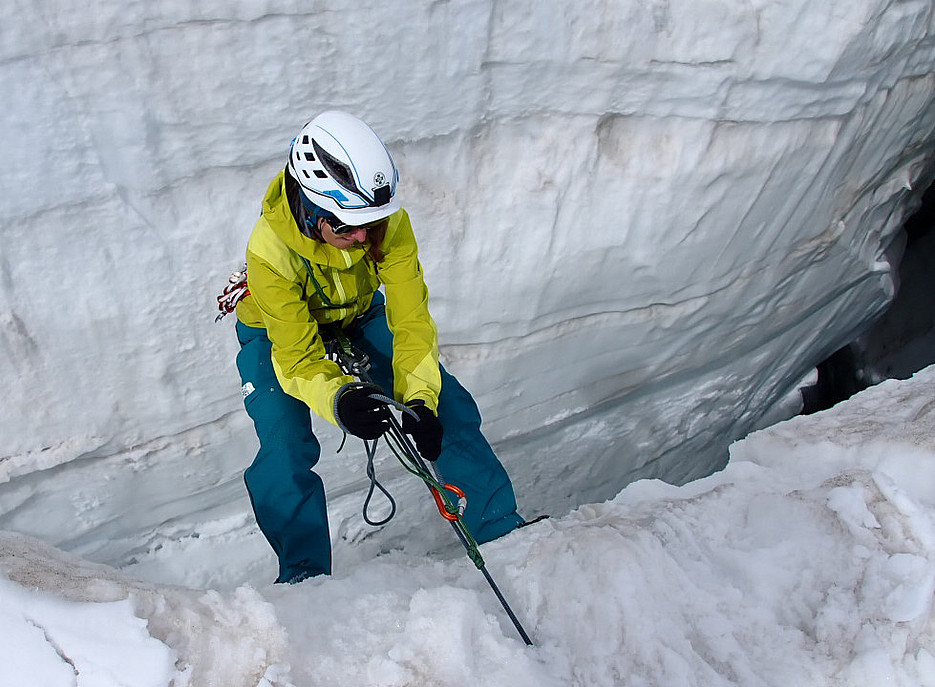 Woman with helmet and alpine clothing abseils into a crevasse ©Thomas Zölss