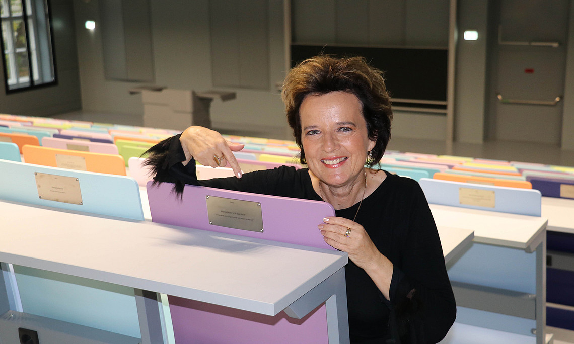 Monika Martin mit dem von ihr gestifteten Stuhl im neuen Alumni-Hörsaal der UB Foto: Uni Graz/ Carmen Teubenbacher