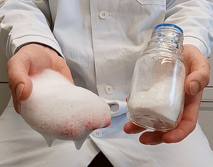 Eine Hand, in der Schaum liegt und eine Hand, die eine Glasflasche hält. ©beigestellt
