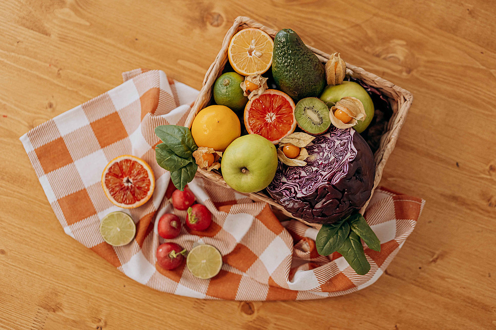 A box full of fresh fruit and vegetables, including apples, oranges, kiwi, avocado and cabbage. ©Pexels/Mikhail Nilov