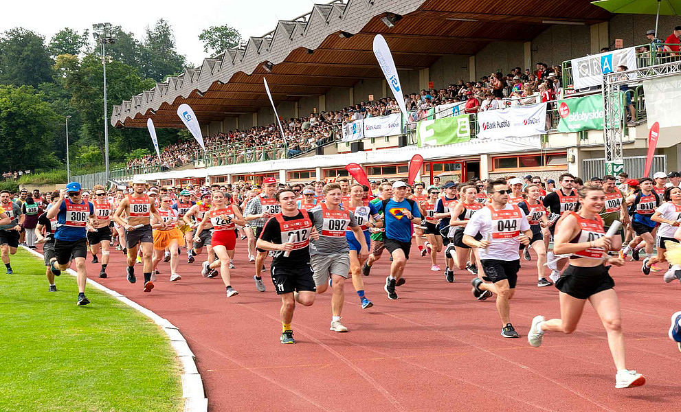 Viele Menschen laufen über eine Laufbahn