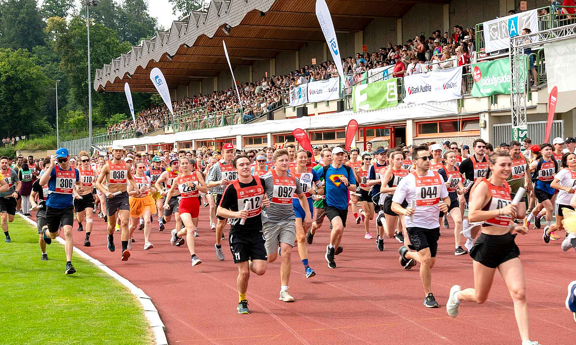 Viele Menschen laufen über eine Laufbahn