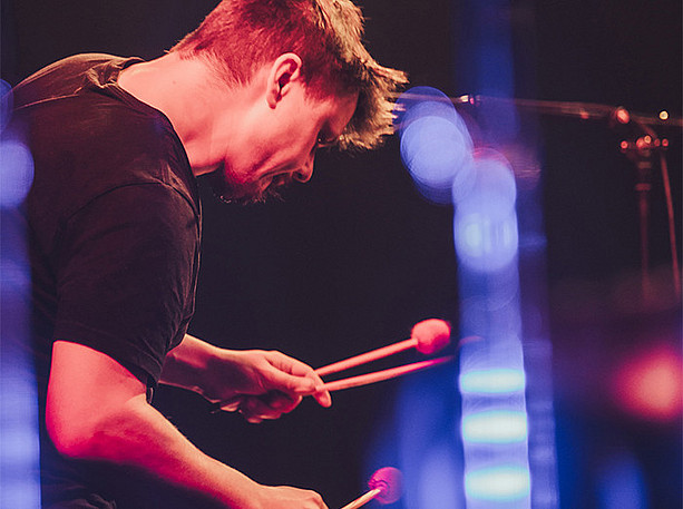 Raphael Meinhart, Musiker, mit Schlagzeug-Sticks live bei einem Konzert, Uni-Fest Universität ohne Grenzen ©Reithofer Media