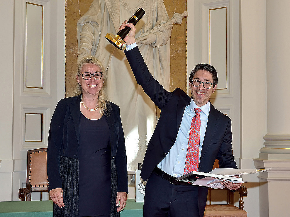 Walter Doralt haltet der Preis hoch neben Catherine Walter-Laager, Vizerektorin für Studium und Lehre 