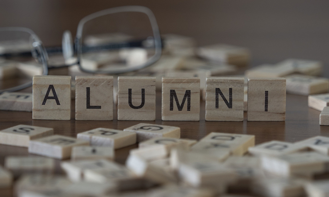 Scrabble-Steine die das Wort Alumni bilden