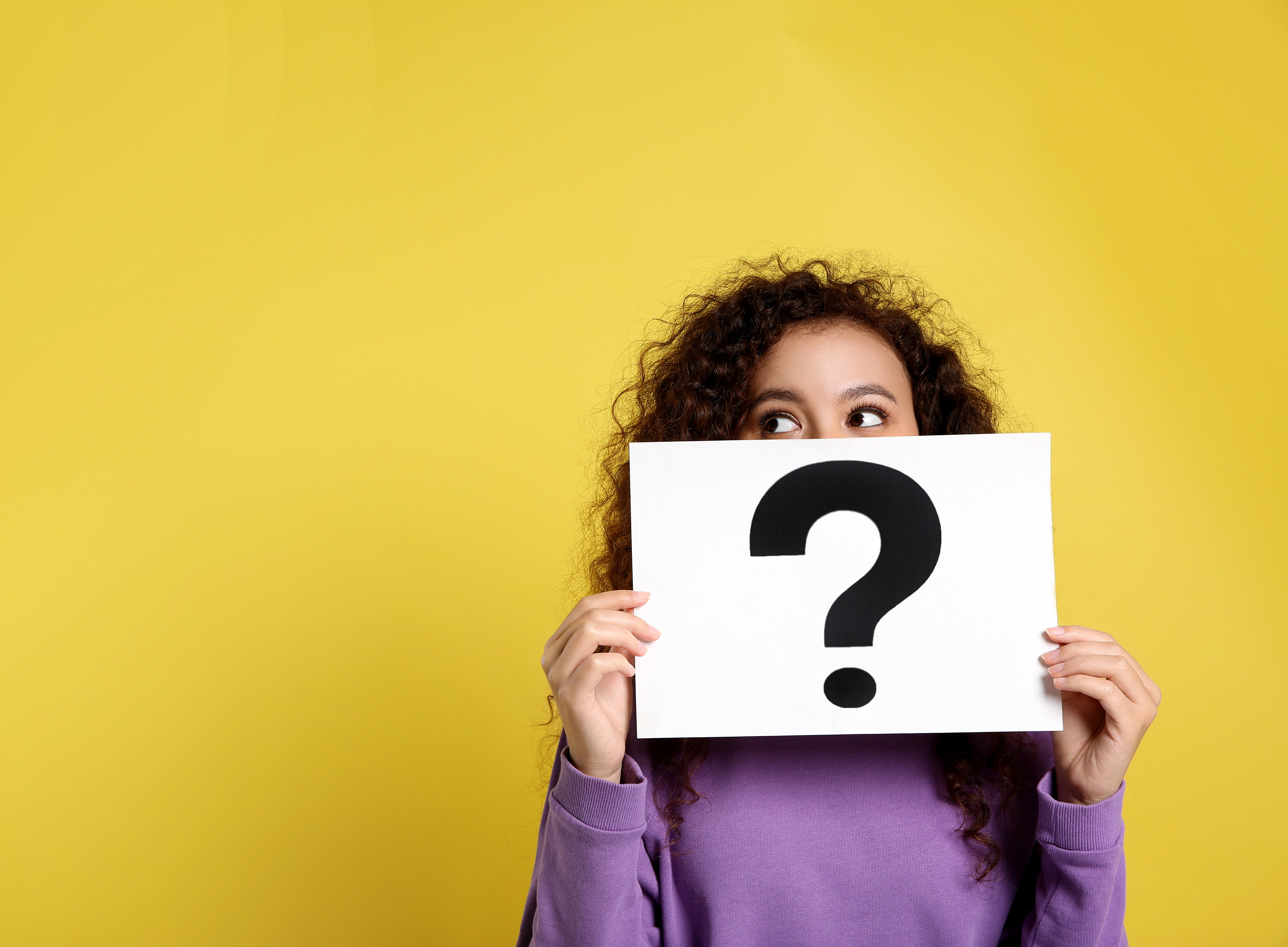 African-American woman with question mark sign on yellow background. ©Olga Yastremska, New Africa, Africa Studio