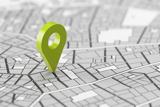 Grüne GPS Standort Markierung in 3D auf einem grauen Stadtplan
