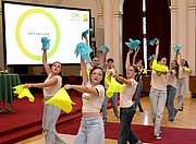 Dancing high school students with yellow and blue scarves in their hands in the auditorium