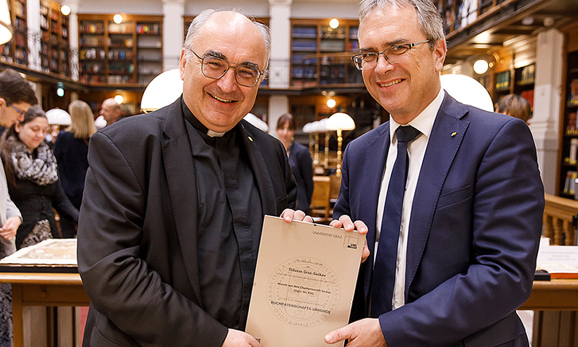 Für die Buchpatin Diözese Graz-Seckau nahm Bischof Wilhelm Krautwaschl die Buchpatenschaften-Urkunde von Rektor Peter Riedler entgegen. Foto: Uni Graz/Luef 