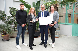 Four people present the seal of approval for workplace health promotion, Rector Riedler, Anita Bregenzer and two BVAEB employees ©Uni Graz/Schweiger