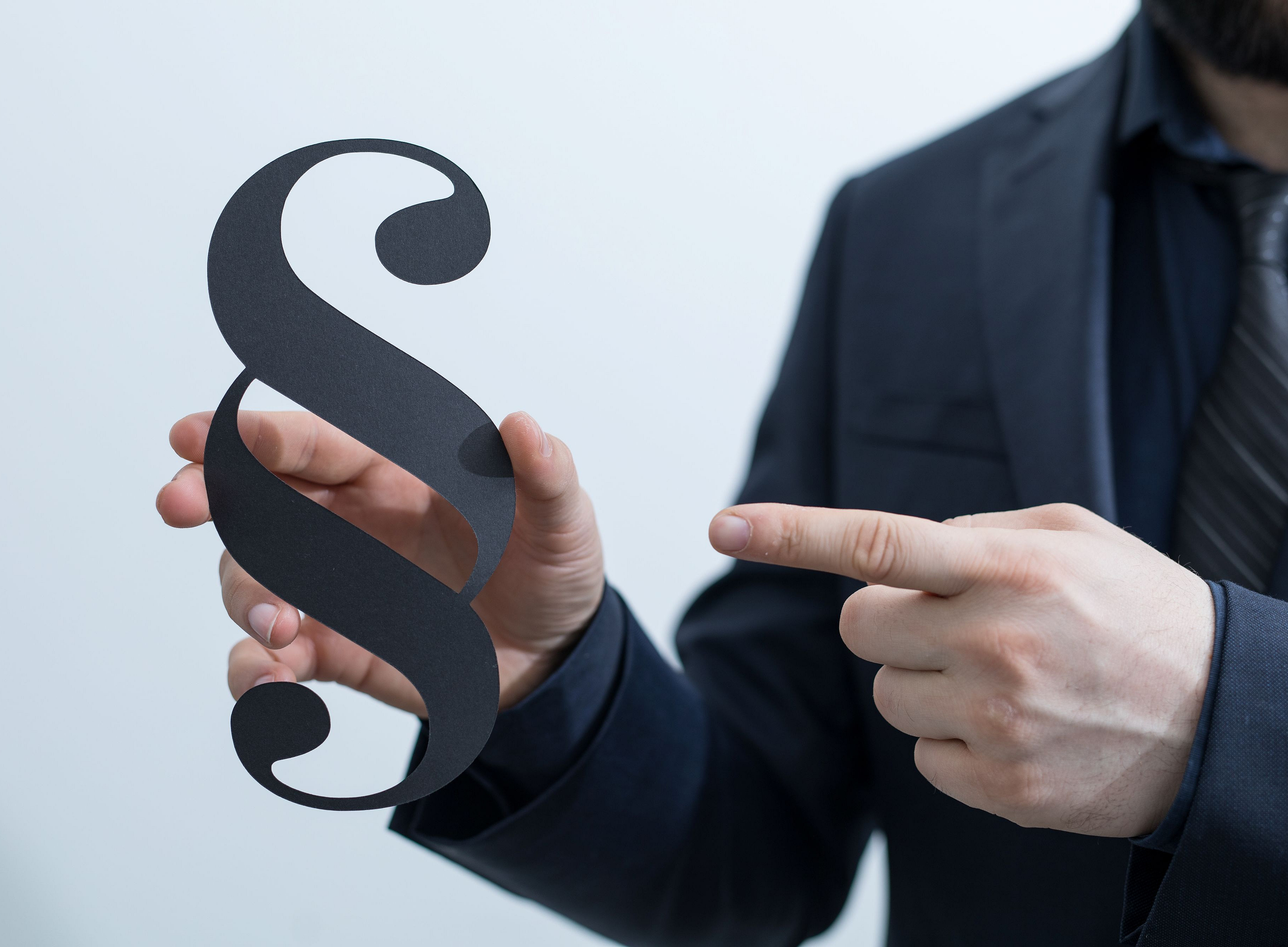 Mann zeigt auf ein Paragraph-Zeichen © vegefox.com by Adobe Stock