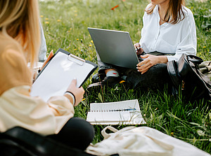 zwei Studierende sitzen mit ihren Laptops auf der Wiese ©Kateryna Hliznitsova | Unsplash