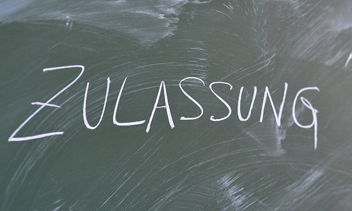 grüne Tafel mit der Kreide-Aufschrift "Zulassung". Foto: Uni Graz
