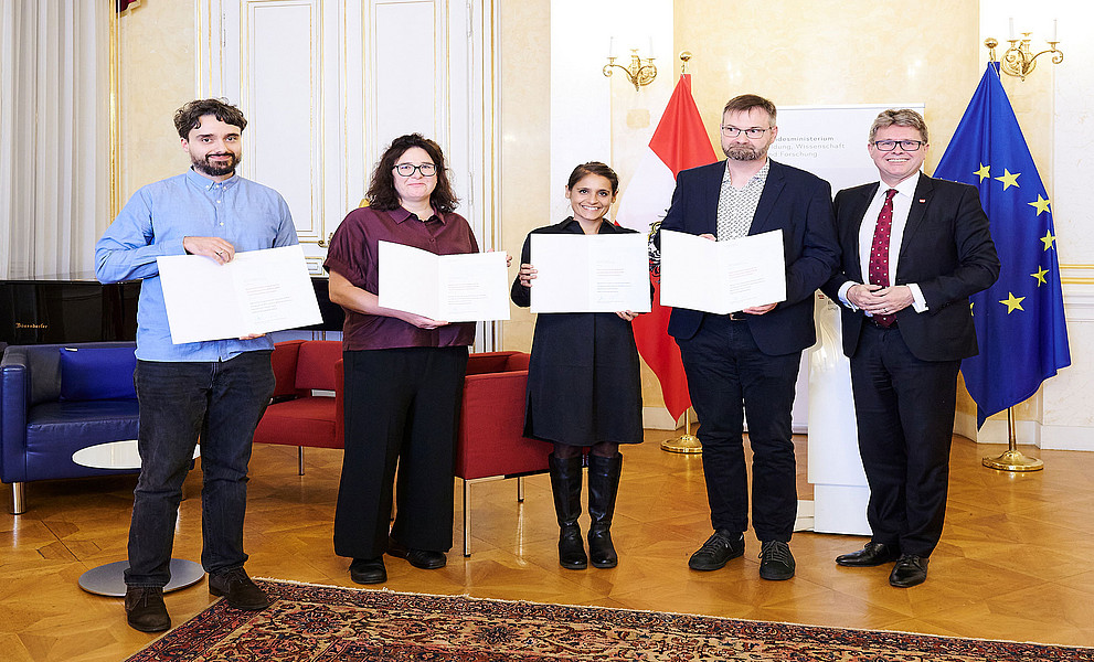 Gruppenfoto der Träger:innen des Staatspreises Geschichte innovativ mit den Urkunden und Minister Martin Polaschek