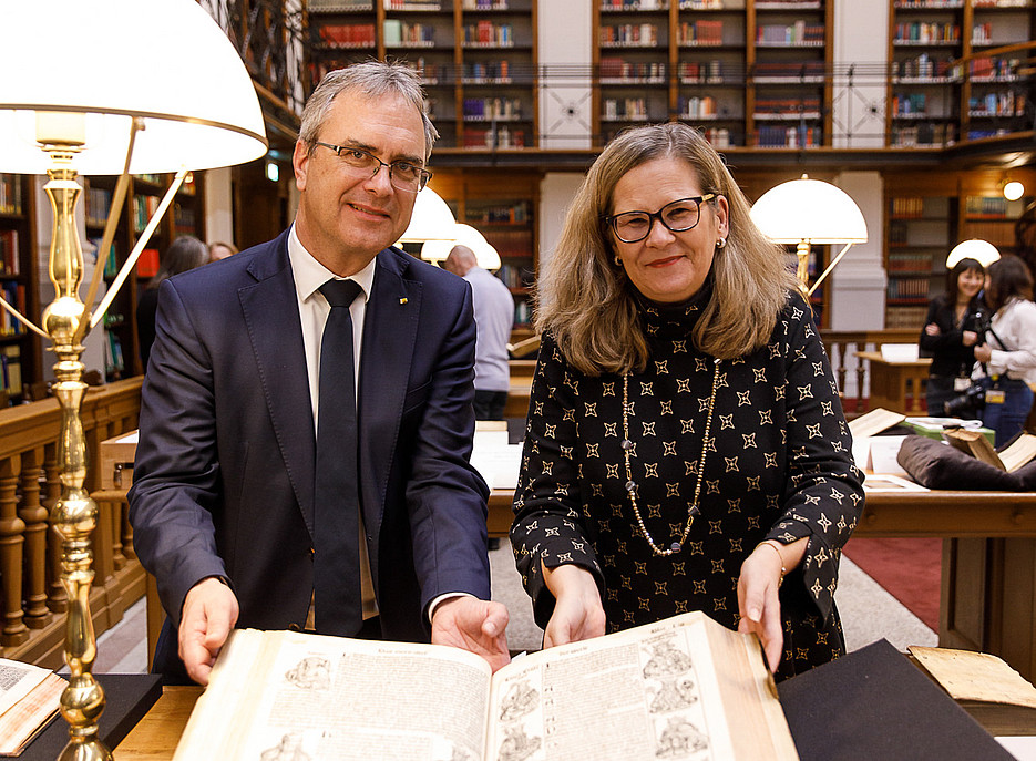 Ein Mann und eine Frau mit einer mittelalterlichen Handschrift ©Uni Graz/Luef