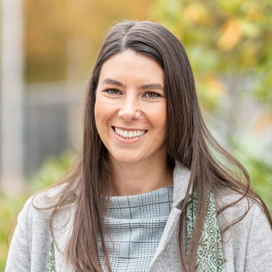 Porträt einer jungen Frau mit langen braunen Haaren und heller Kleidung
