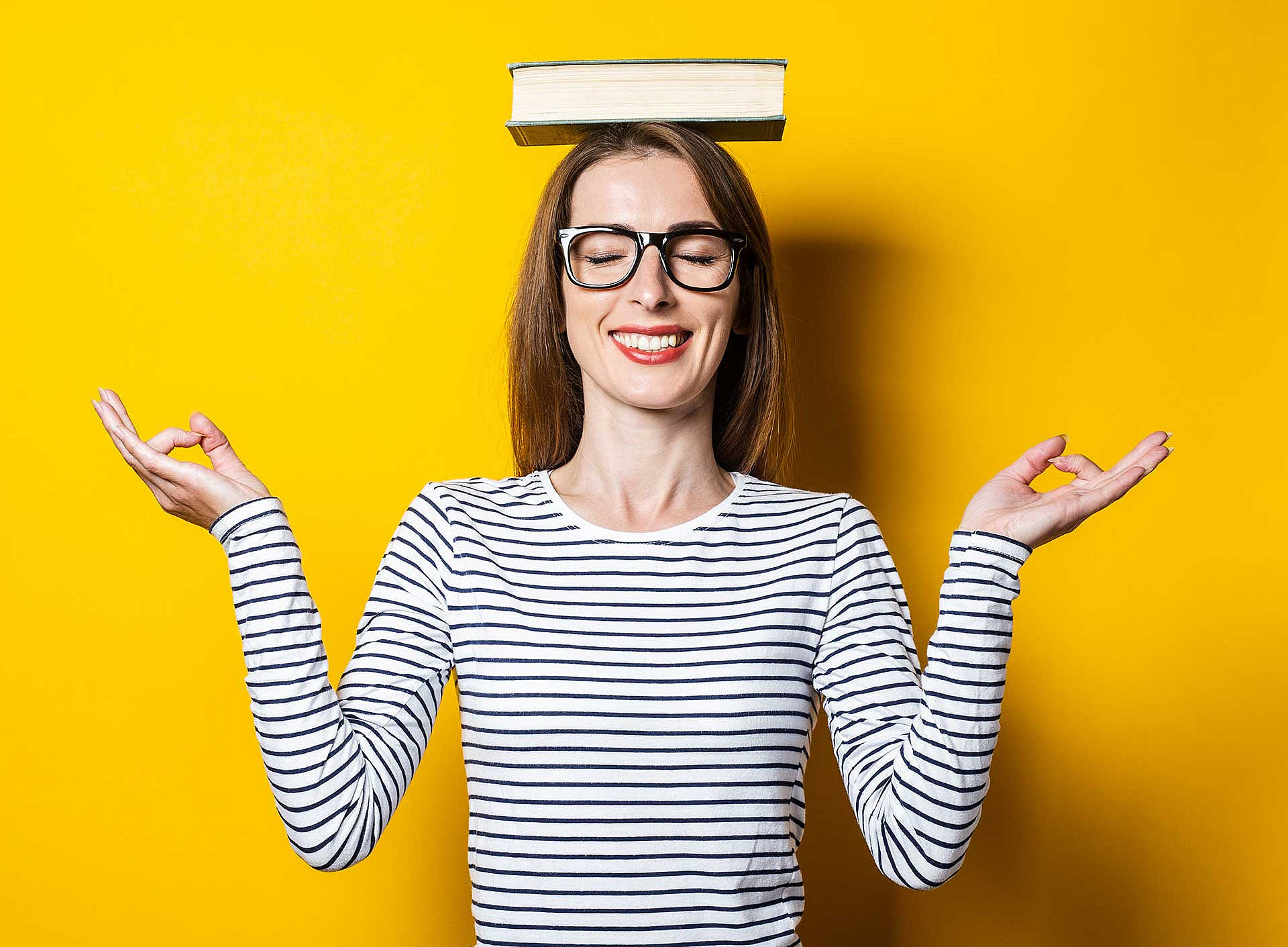 Frau hält ein Buch auf dem Kopf in Balance 