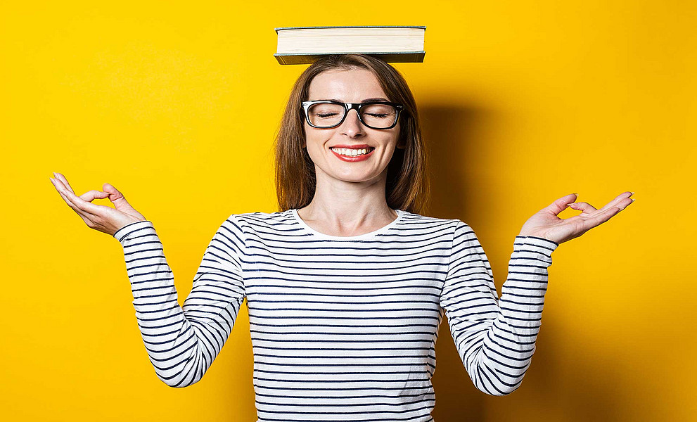 Frau hält ein Buch auf dem Kopf in Balance