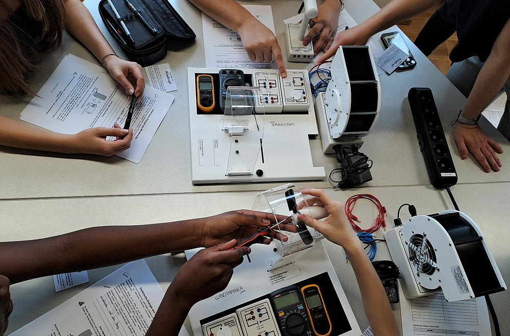 Eine Gruppe von Leuten die auf einem Tisch sitzen und gemeinsam wissenschaften ©Uni Graz/Obczovsky