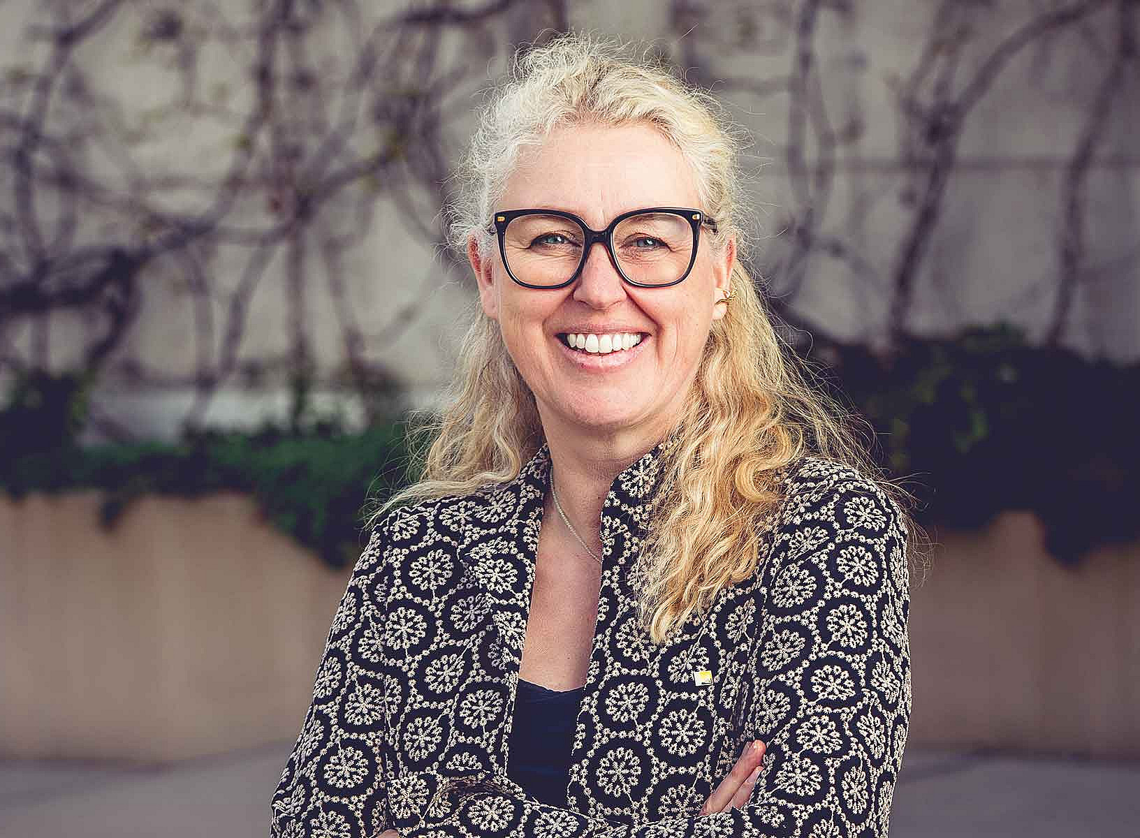 A woman with long hair is smiling at the camera 