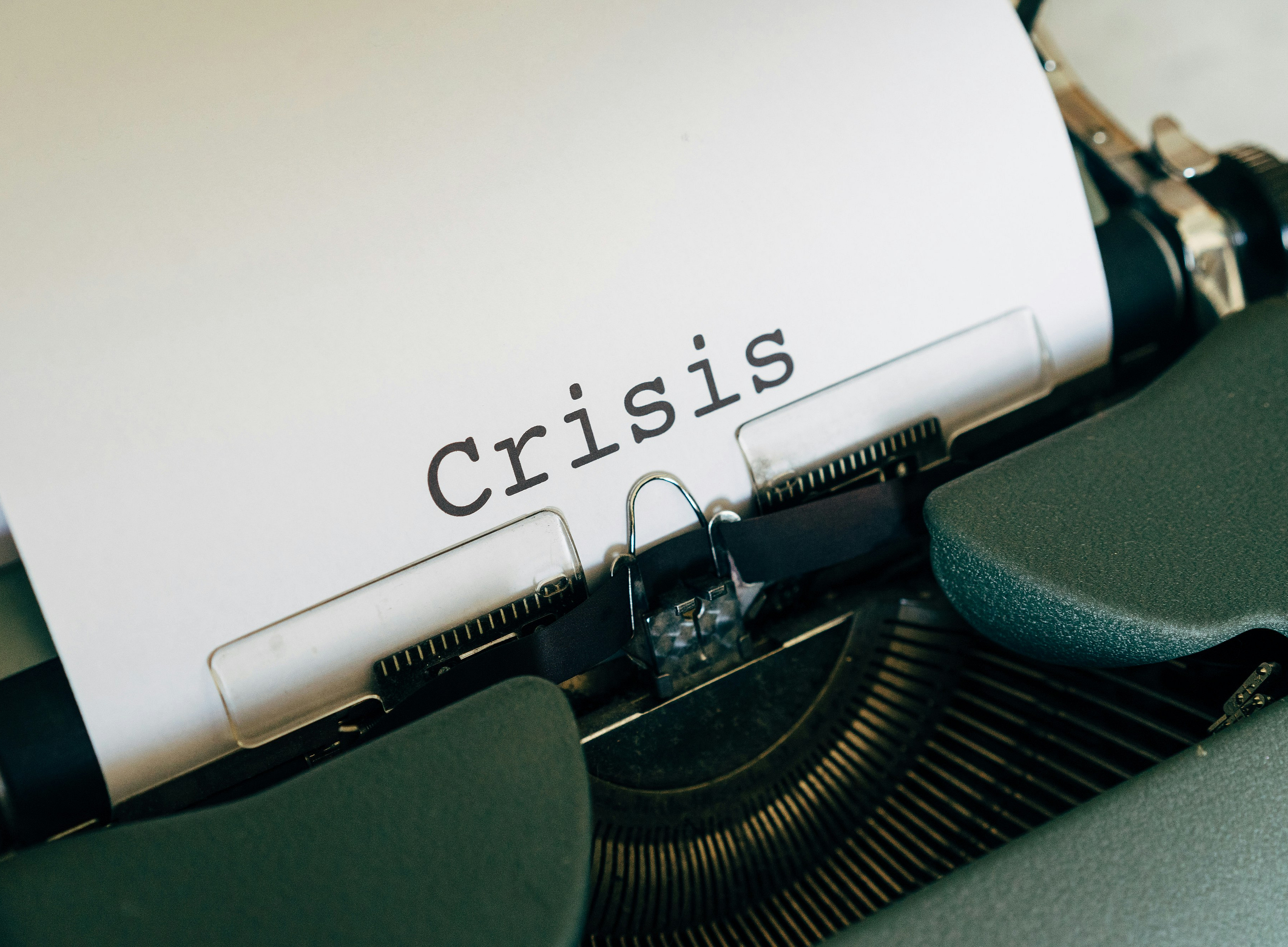 Mechanische Schreibmaschine, darin ein Blatt mit dem zentriert gesetzten Wort "crisis" ©Markus Winkler, unsplash.com