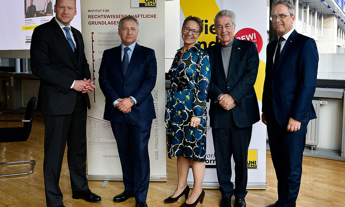 Dekan Christoph Bezemek, Markus Steppan, Leiter des Instituts für Rechtswissenschaftliche Grundlagen, Rechtshistorikerin Anita Ziegerhofer, Bundespräsident a.D. Heinz Fischer, Rektor Peter Riedler (v.l.) vor zwei Roll-ups der Rechtswissenschaftlichen Fakultät der Uni Graz