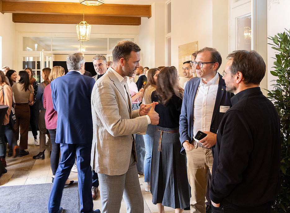 Menschen stehen zusammen in Kleingruppen und reden miteinander ©Harry Schiffer