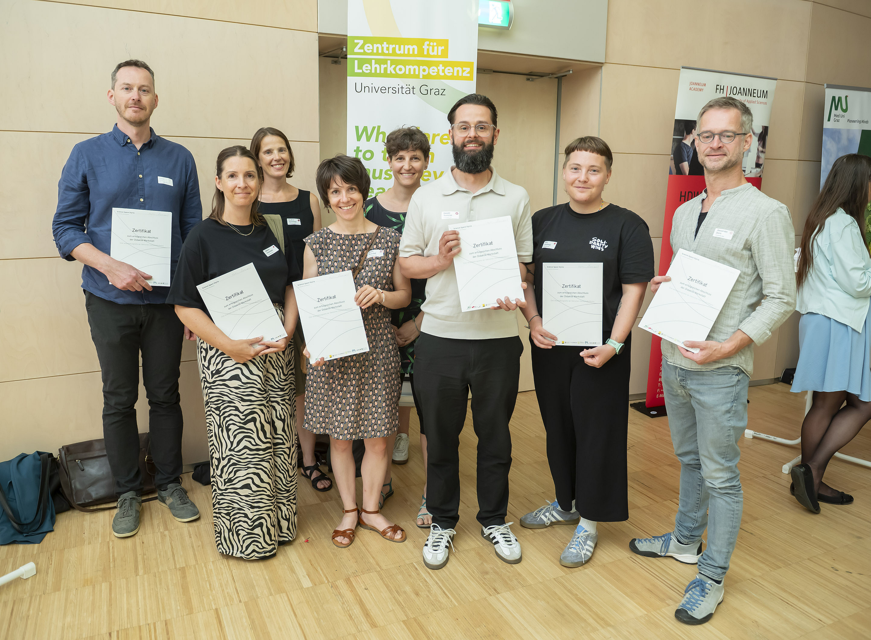 Im Vordergrund die Uni Graz-Absolvent:innen der Didaktik-Werkstatt 2026. Im Hintergrund Dr.in Gudrun Salmhofer, Leiterin der Abteilung Lehr- und Studienservices, und Dr.in Lisa Scheer, Mitarbeiterin des Zentrums für Lehrkompetenz. ©Foto Fischer