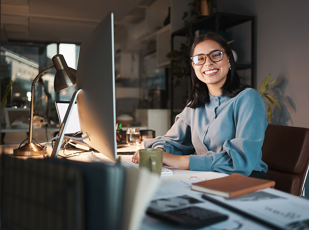 Junge Frau sitzt am Schreibtisch mit einem Computer ©Rene L/peopleimages.com - stock.adobe.com