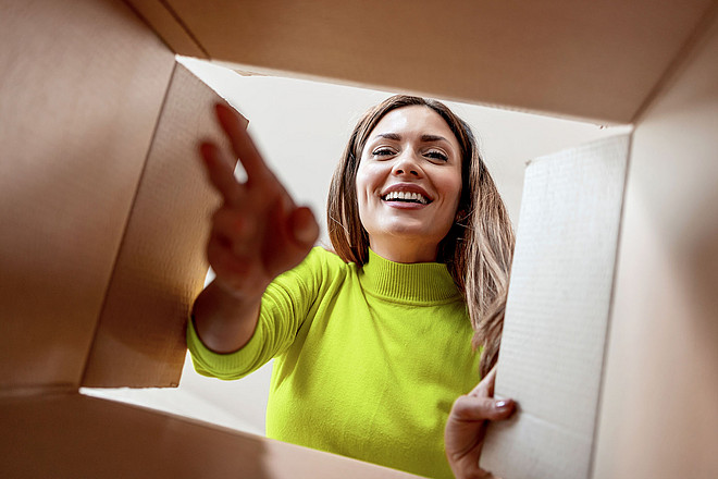 Woman with open box,view from inside.Excited girl unboxing cardboard delivery package.