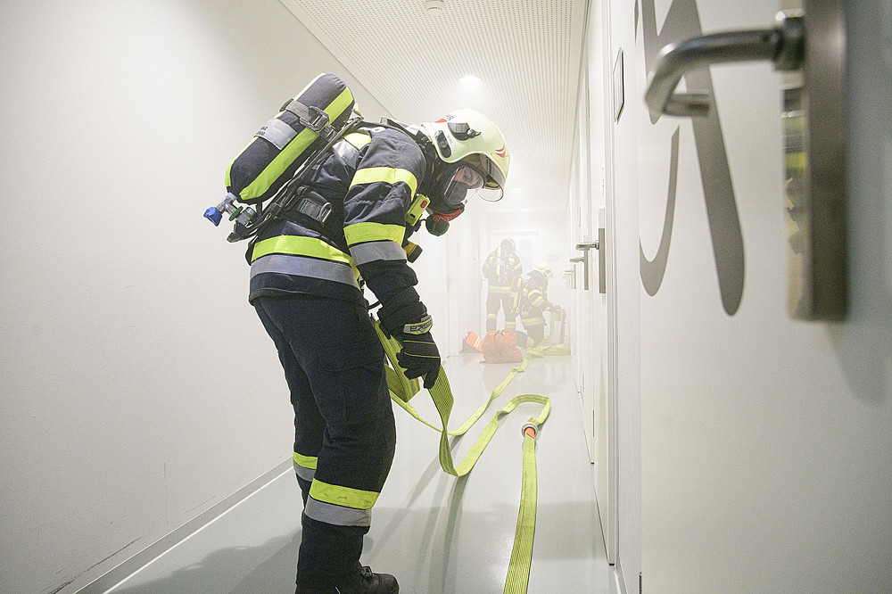 Eine Person in Feuerwehr-Montur im Einsatz beim Legen eines Schlauchs ©Uni Graz/Tzivanopoulos